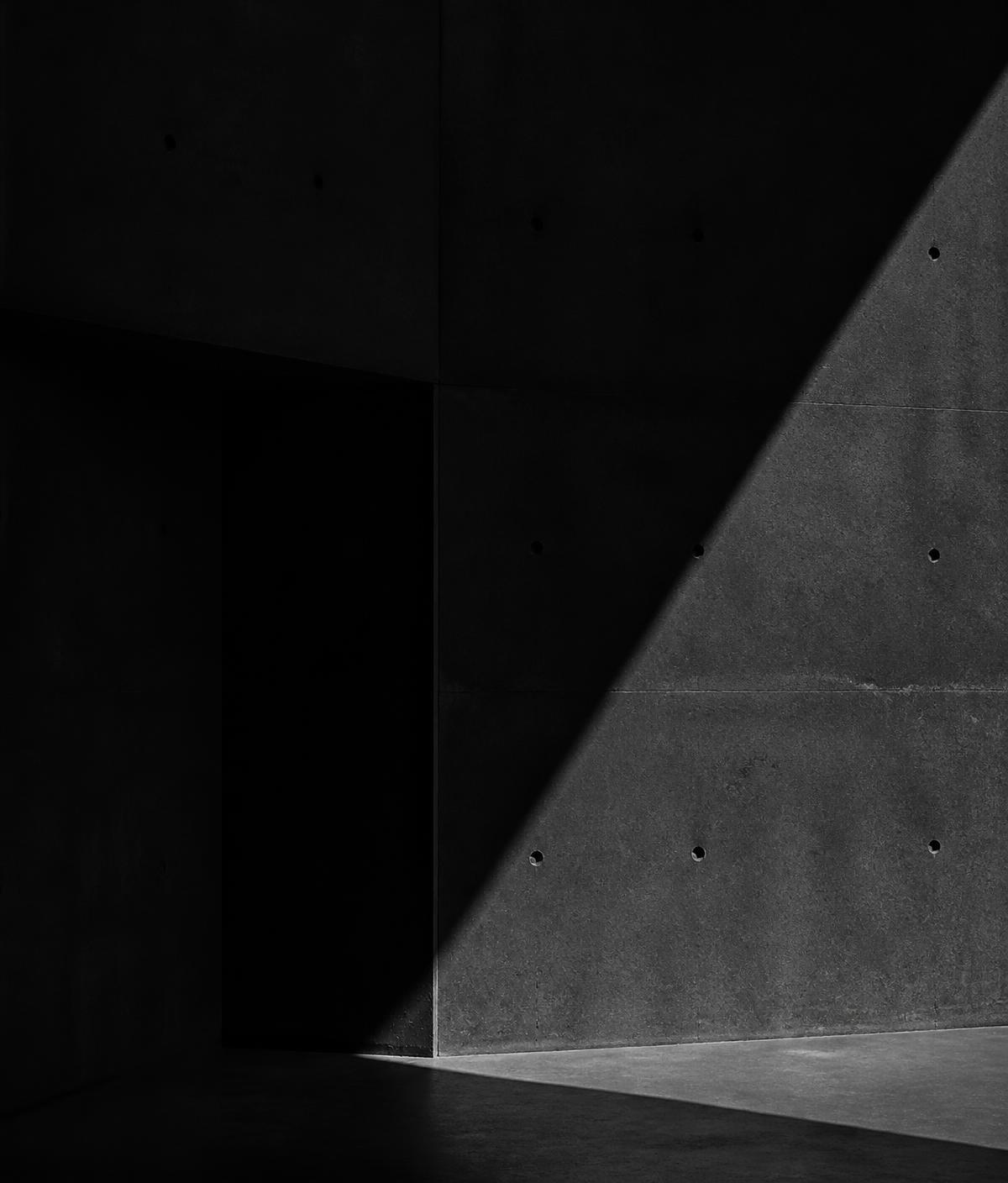 Dark concrete wall cut by a sharp diagonal of light