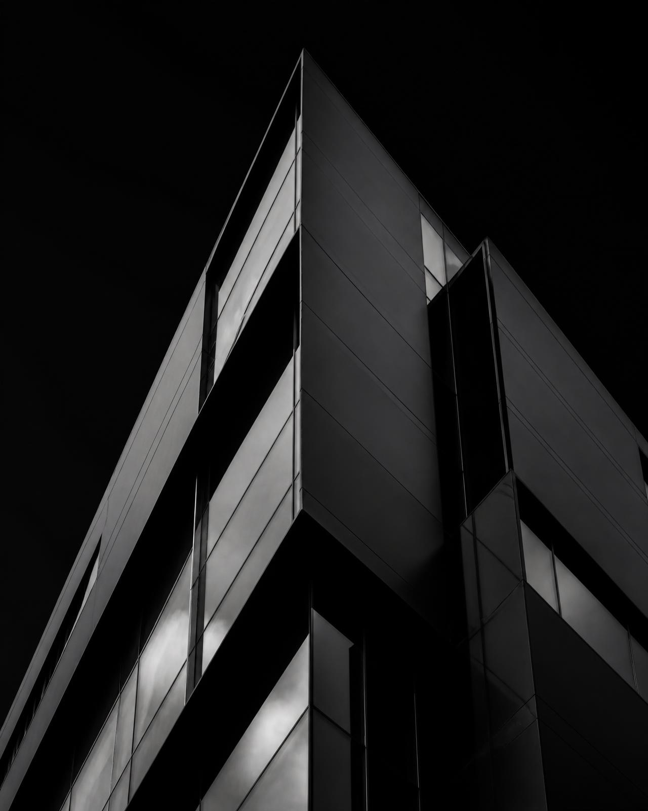 Dark geometric architecture with sharp steel and glass planes